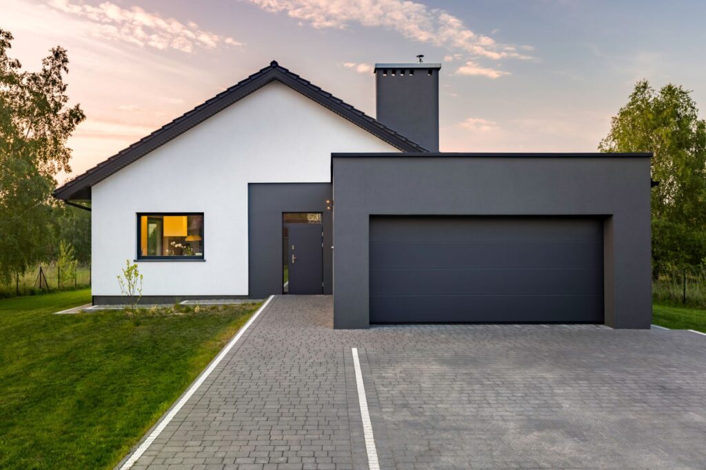 Modernes Einfamilienhaus mit dunkler Garage.